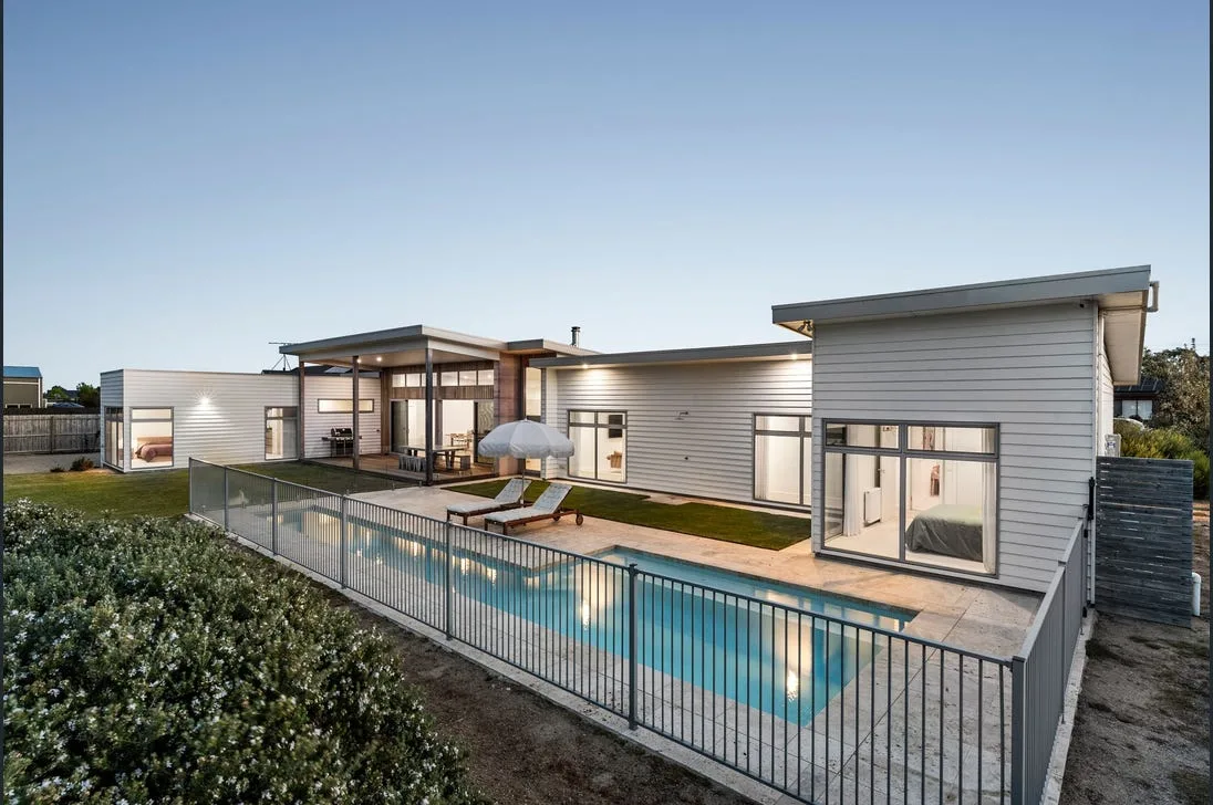 Black powder-coated aluminium pool fencing around a modern pool at dusk