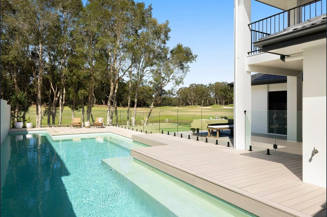Frameless glass pool fence around a modern Brisbane home with polished concrete decking